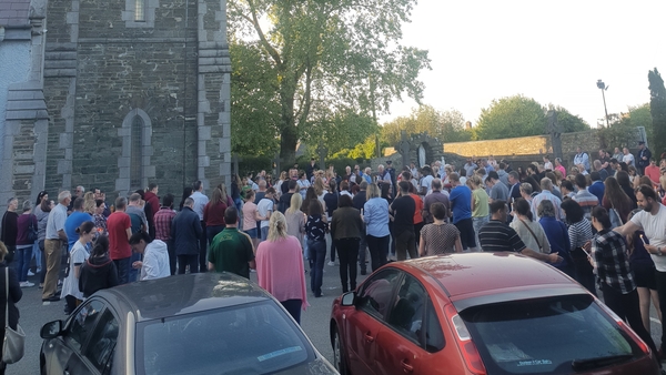 Hundreds of people gathered outside the packed church holding candles