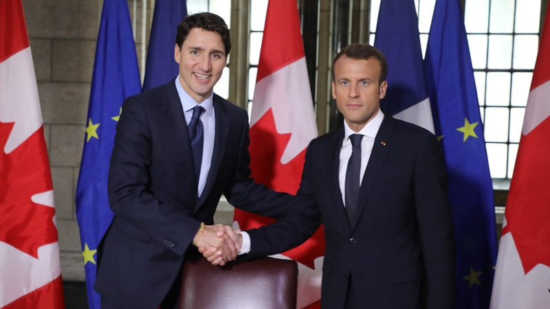 Canadian Prime Minister Justin Trudeau (L) welcomes French President Emmanuel Macron at parliament in Ottawa