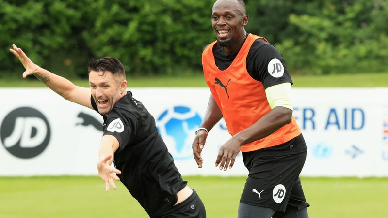 Usain Bolt (R) and Robbie Keane of the Rest of the World take part in training for Soccer Aid for UNICEF