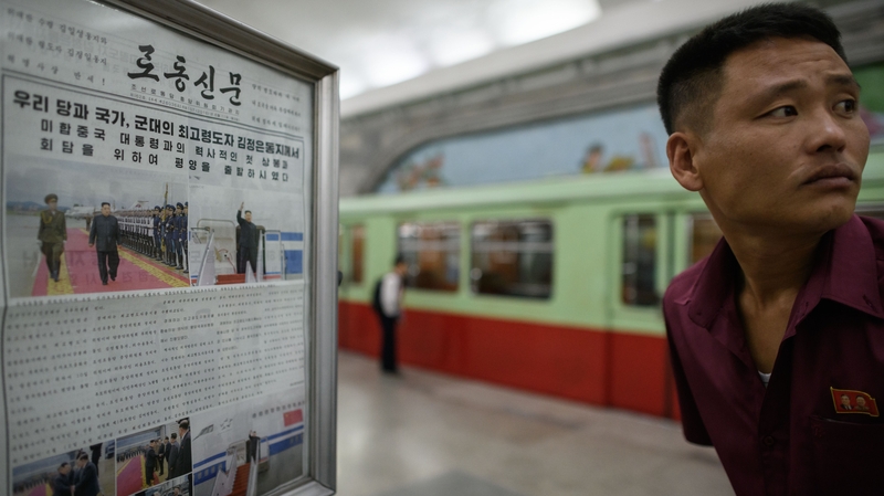 A displayed North Korean newspaper on the Pyongyang subway showing images of leader Kim Jong-un in Singapore ahead of his meeting with US president Donald Trump