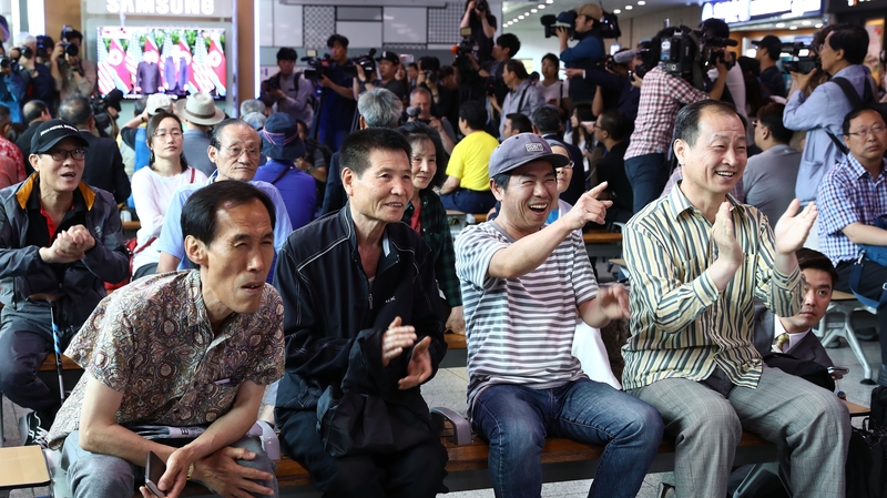 South Koreans watch on a screen reporting on the US President Trump meeting with North Korean leader Kim Jong-un at Seoul Railway Station