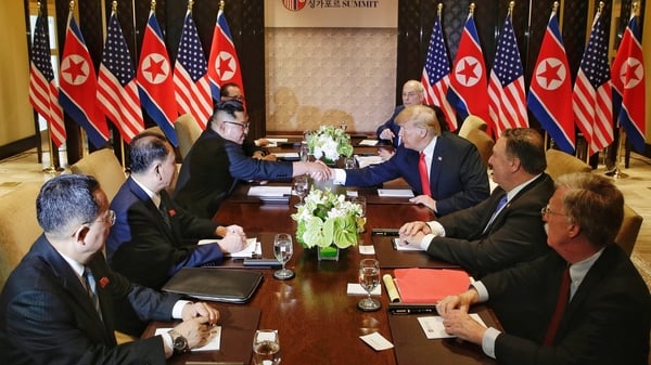 US President Donald Trump and North Korea's leader Kim Jong Un shake hands as they sit down with their delegations for the US-North Korea summit at the Capella Hotel in Singapore