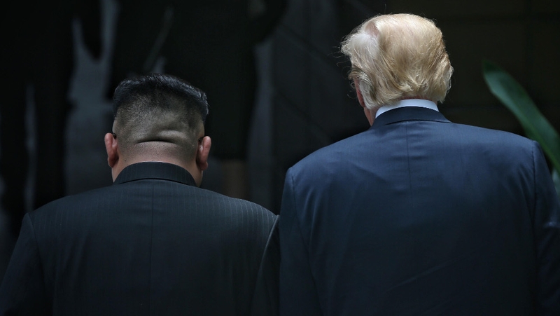 US President Donald Trump (R) and North Korean leader Kim Jong-un (L) stroll on the grounds of Capella Hotel after their working lunch