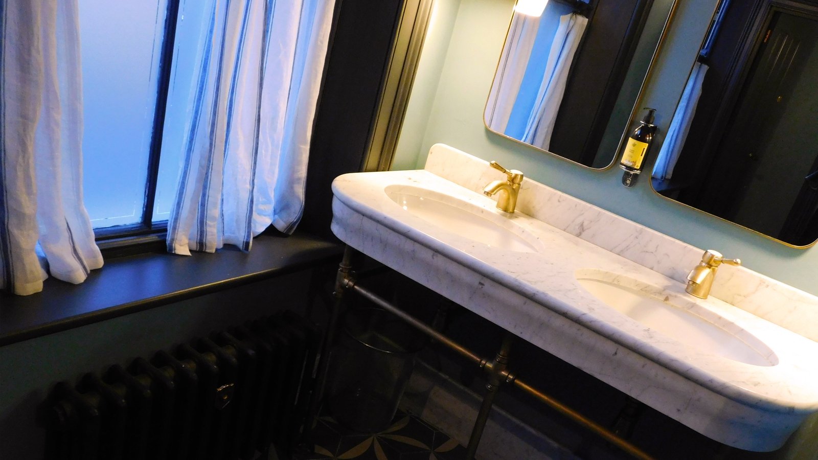 Marble sink, linen wall panels and satin brass details in the bathroom