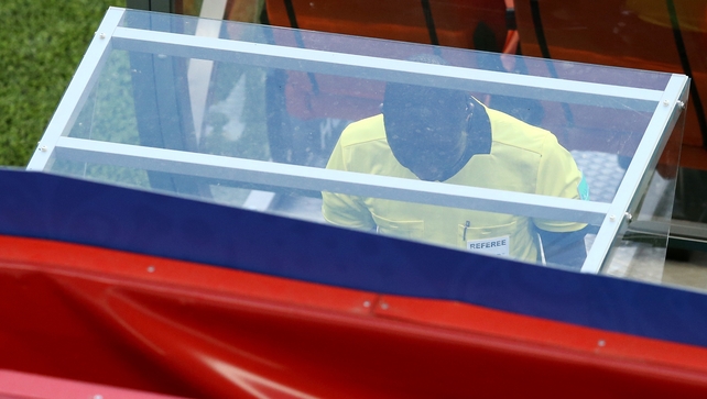 Referee Bakary Gassama reviews the video replay before awarding a penalty to Peru
