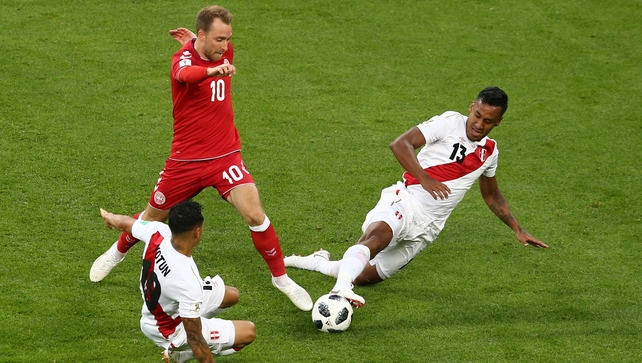 Yoshimar Yotun and Renato Tapia of Peru challenge Christian Eriksen