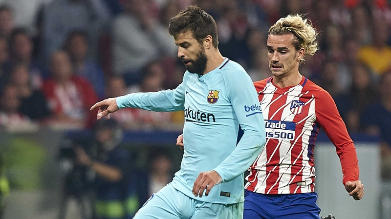 Gerard Pique (L) in action against Antoine Griezmann