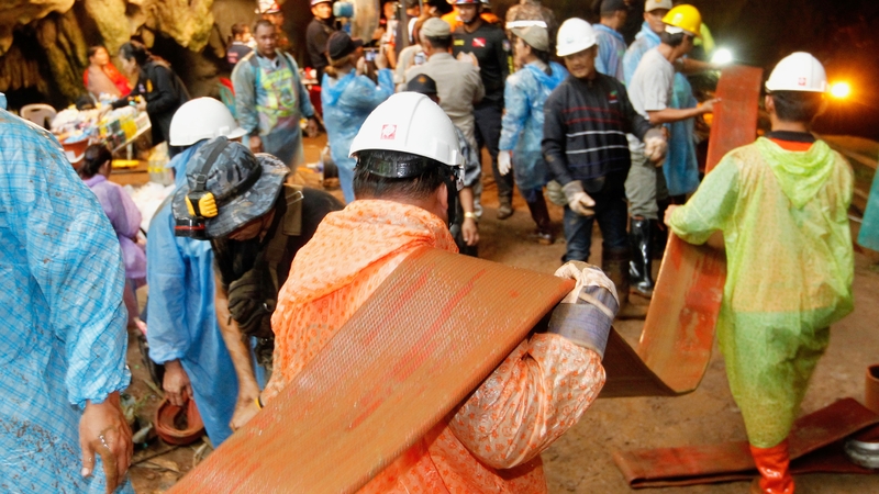 Rescue workers are using hoses to try and pump water out of the flooded cave