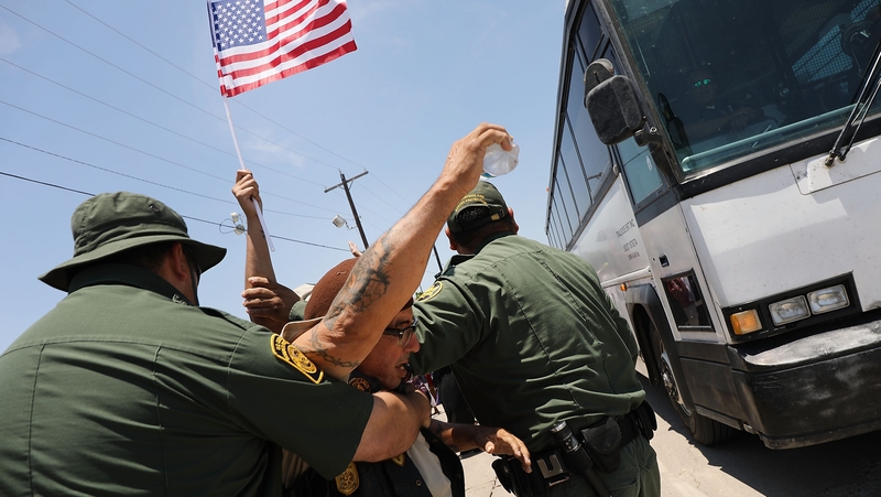 Protesters try to block a bus carrying migrant children out of a US Customs and Border detention centre in Texas