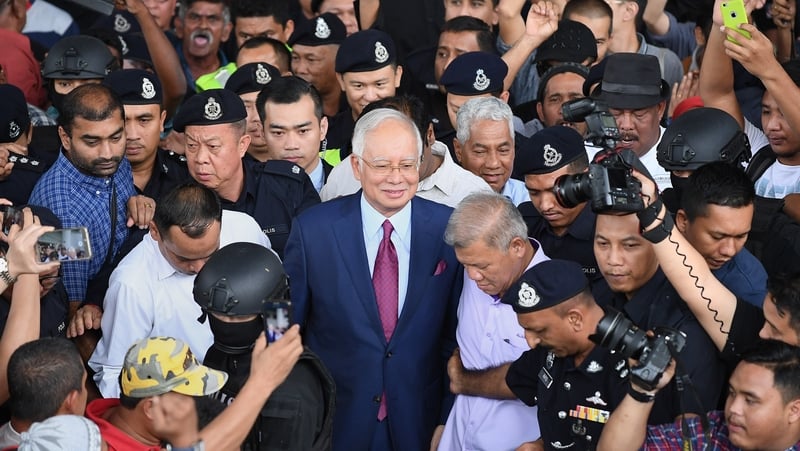 Najib Razak surrounded by police media and supporters outside court