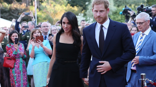 Professional and amateur photographers strain to capture an image of the couple