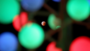The moon seen as it passes through decorative lights in Kuwait City