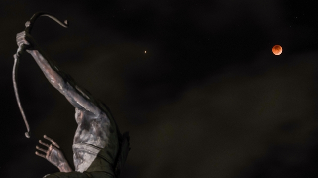 This picture shows the 'blood moon' eclipse behind a statue in Yogyakarta, Indonesia