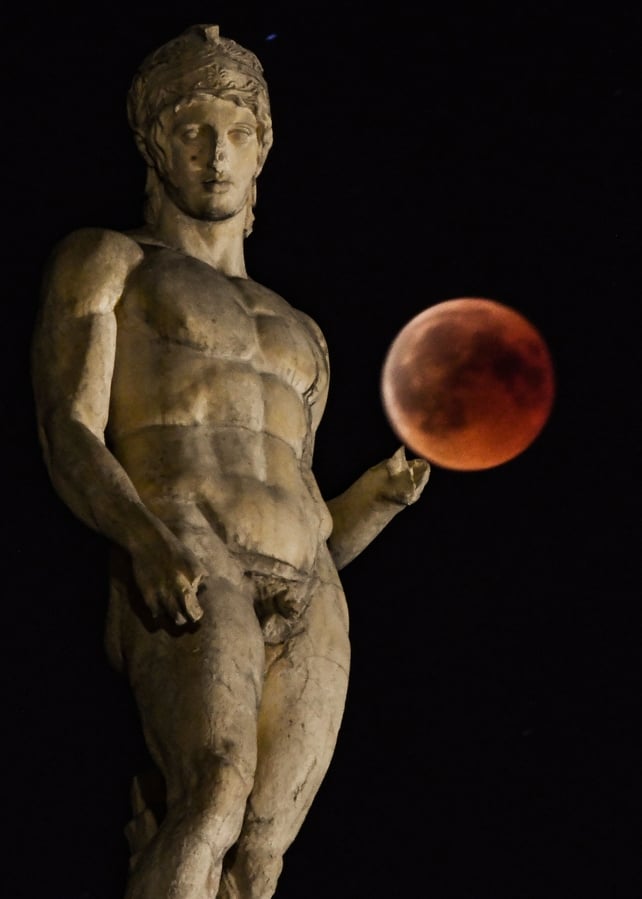 'Blood moon' eclipse beside a statue of ancient Greek god Ares in central Athens