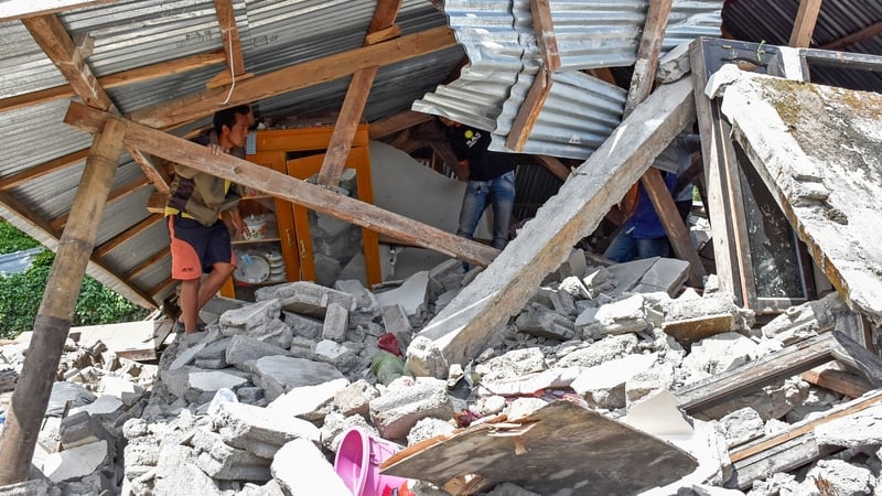 An Indonesian man looks at the remains of a house after the earthquake struck