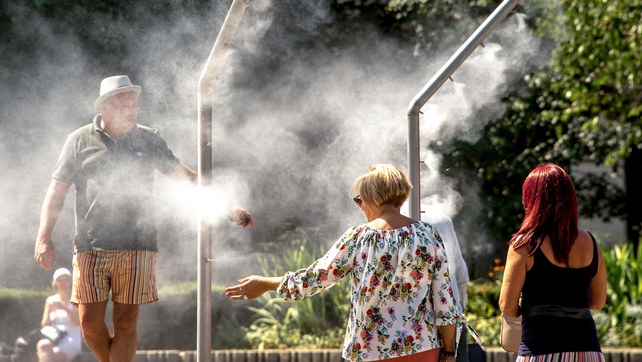 People cool off under water sprays in Lille, northern France