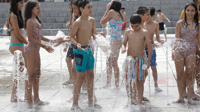 Children refresh themselves in a fountain in Coruche, Santarem, Portugal