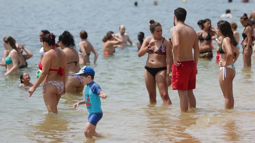 People bathe at the Santo Amaro beach in Oeiras near Lisbon, Portugal