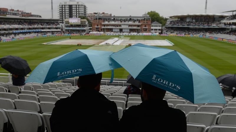 Spectators under umbrellas at Lord's