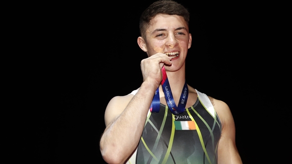 Rhys McClenaghan poses for photos following the gold medal presentation