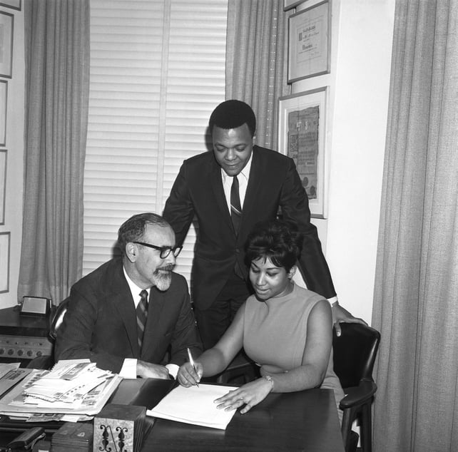 Aretha Franklin signs her contract with Atlantic Records (L-R Jerry Wexler, husband and manager Ted White and Aretha franklin) on November 21, 1966 in New York City, New York. (Photo by PoPsie Randolph/Michael Ochs Archives/Getty Images)