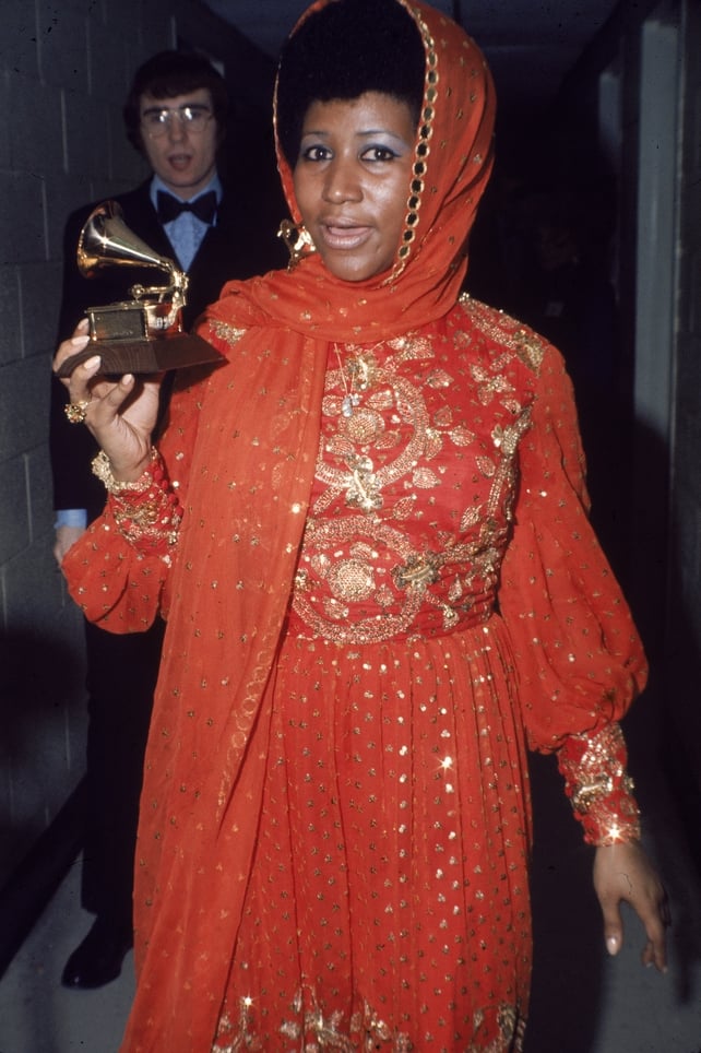 Aretha Franklin stands backstage wearing an gold embroidered gown and holding a Grammy Award, circa 1970. (Photo by Tim Boxer/Getty Images)