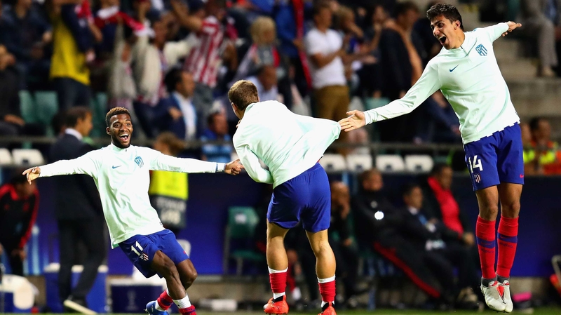 Antoine Griezmann(centre) and Atletico teammates Thomas Lemar (L) and Rodri celebrate their side's fourth goal