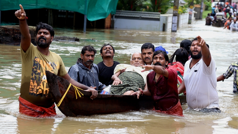 Indian people use a boat to rescue an elderly man in the flooded water in Kochi, Kerala state