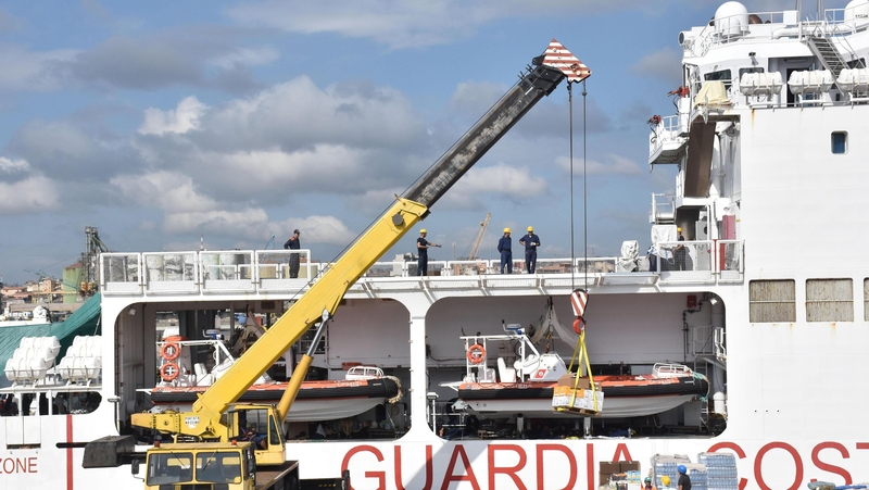 Supplies are loaded onto the Italian coast guard ship Diciotti as migrants wait to disembark, in the port of Catania