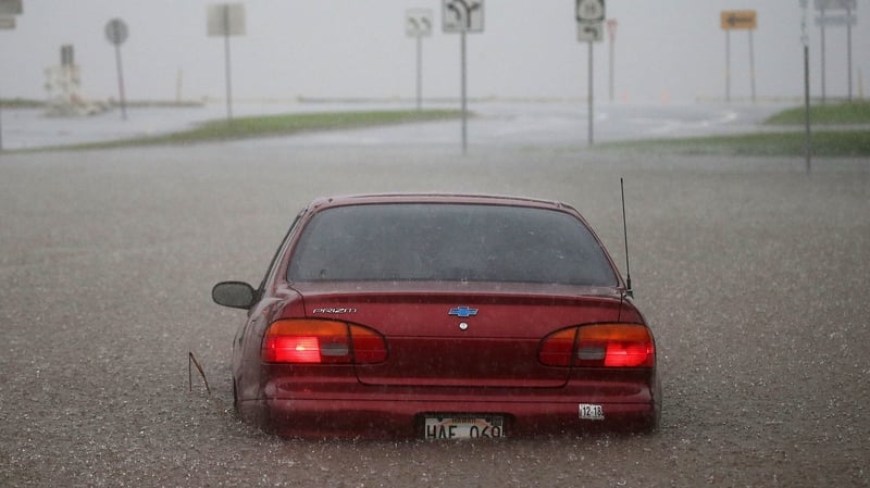 A car stuck partially submerged in floodwaters from Hurricane Lane rainfall on Hawaii's Big Island