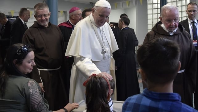 Pope Francis greets a child at the Capuchin Day Centre for the homeless
