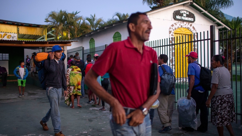 Venezuelan refugees queue to get a free breakfast at a parish centre in the border city of Pacaraima, Brazil