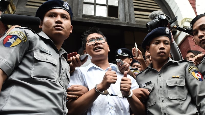 Journalist Wa Lone is escorted by police after being sentenced by a court to jail in Myanmar