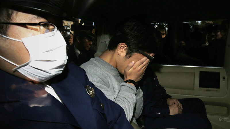 Takahiro Shiraishi covers his face after his arrest last November