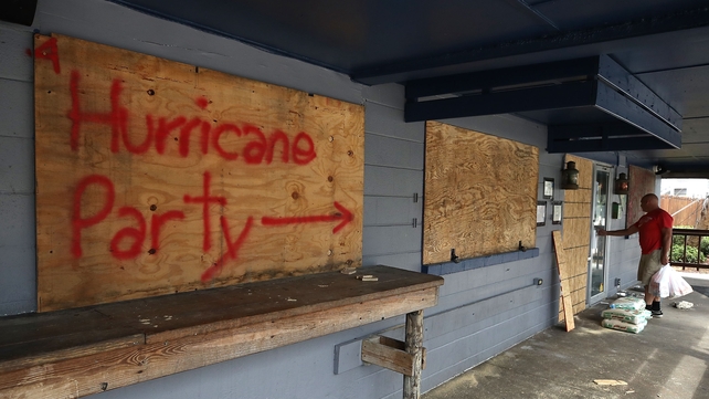 'Hurricane Party' is written on plywood covering the window of the Lager Heads Tavern in Wrightsville Beach