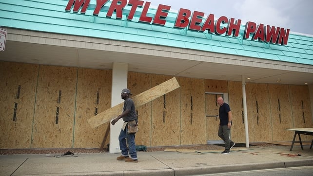 Locals board the windows of a business in Myrtle Beach, South Carolina