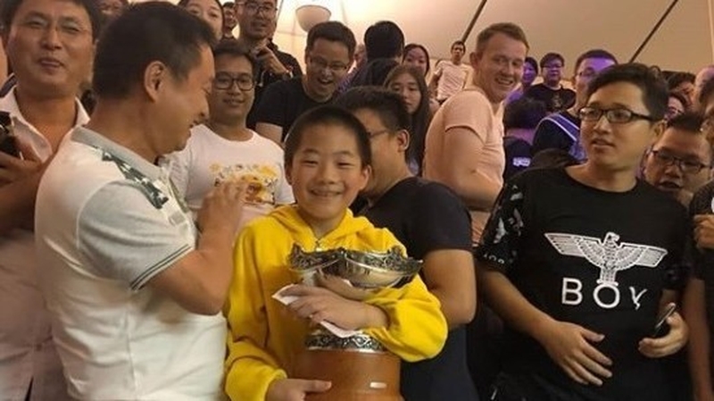 A delighted young fan clutches the trophy