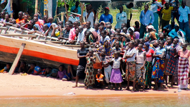 People watch from the banks of Lake Victoria as Tanzanian rescue workers continue to search for victims