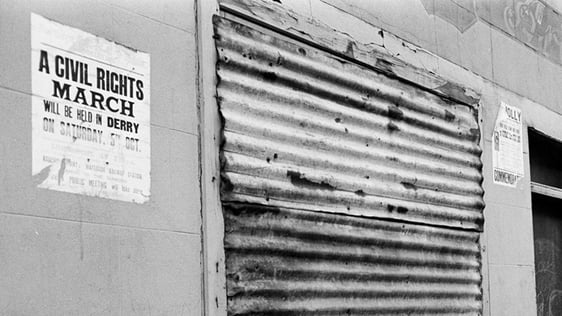 A boarded-up premises in Derry city on 7 May 1969. A notice publicising a civil rights march is vis…