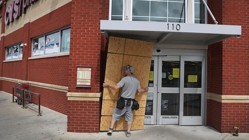 A resident boards over the windows of a shop in Port St. Joe, Florida