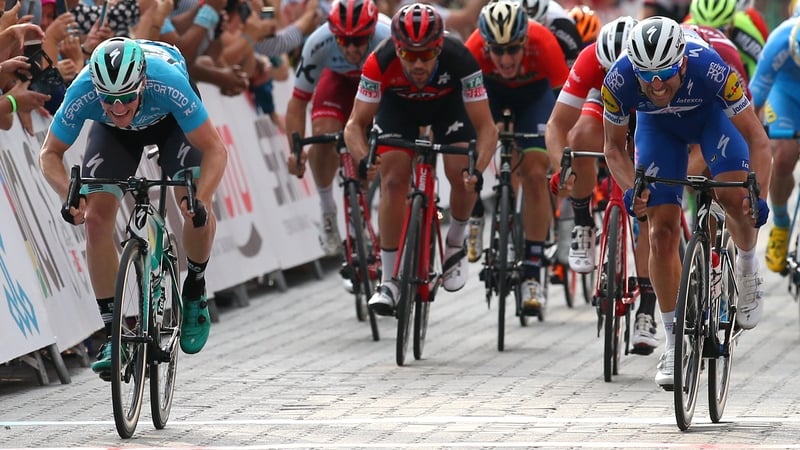 Sam Bennett (left) crosses the finish line in first place
