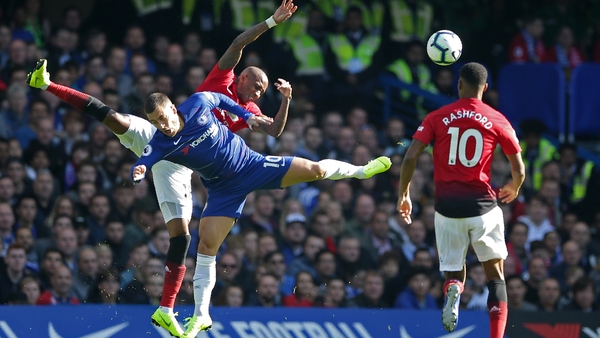 Eden Hazard competes with Ashley Young for the ball