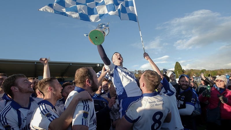 St Patrick's Ciaran Doyle triumphantly hoists the trophy into the air