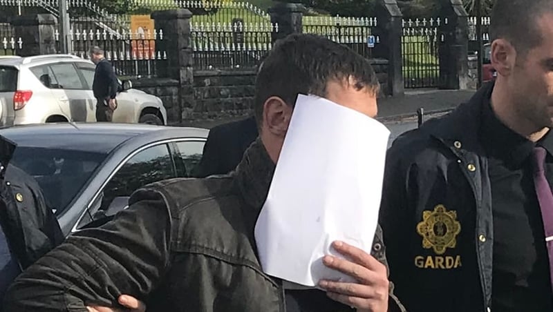 Arnoldas Ivanauskas covers his face as he is brought into court in 2018 (file pic)
