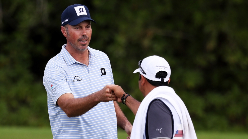 Kuchar and his caddie bump fists on the green in Mexico