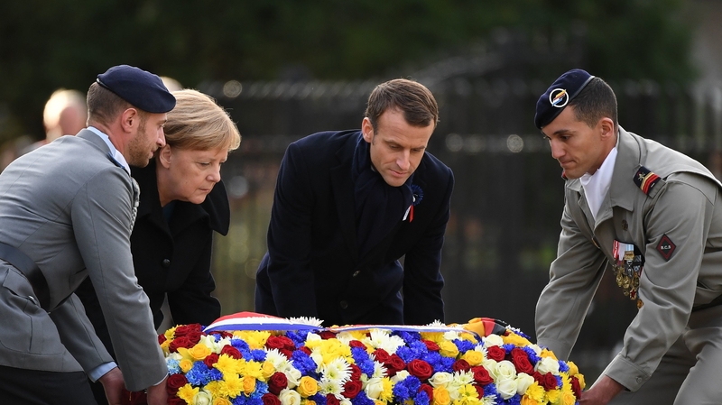 Angela Merkel and Emmanuel Macron lay a floral wreath during the ceremony