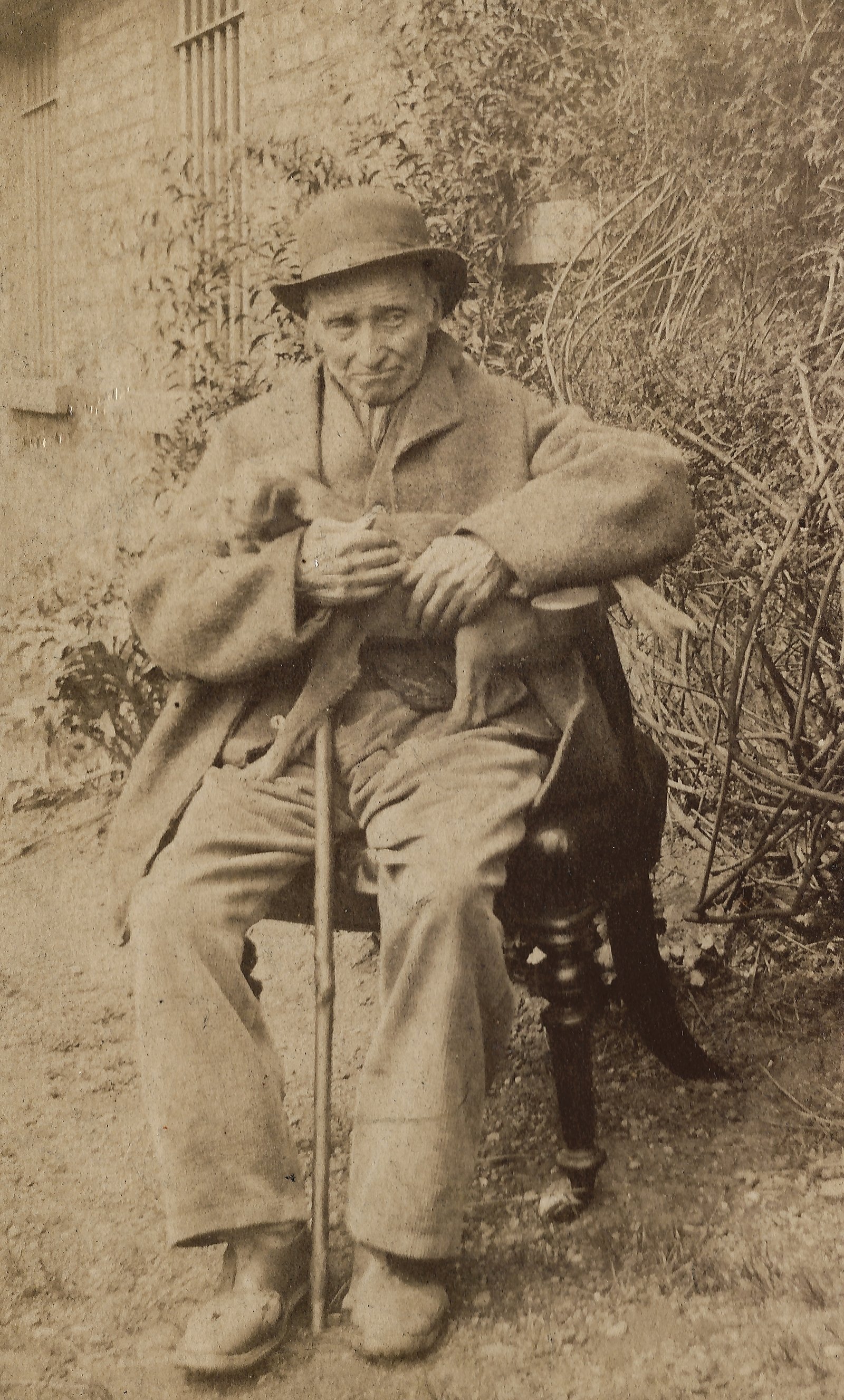 Albumen portrait of James Conway seated outside with cane and hat.