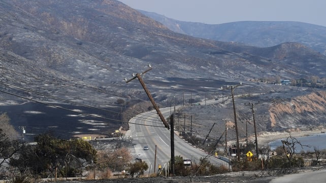 Scorched hillsides and damaged power lines are seen along the Pacific Coast Highway near Leo Carrillo State Beach in Malibu