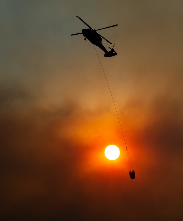 A helicopter en-route to make a water drop in the Feather River Canyon, east of Paradise