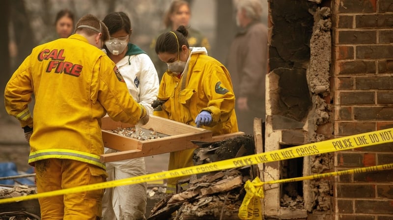Rescue workers sift through debris for human remains at a burned residence in Paradise